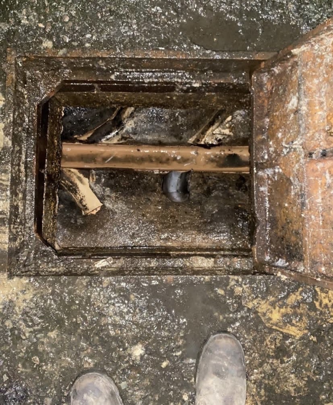 After blocked drain chamber cleaning showing pipework visible and blockage removed