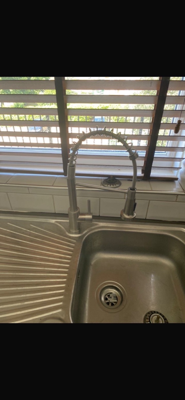 After kitchen tap replacement with modern spring pull out mixer tap installed above the sink