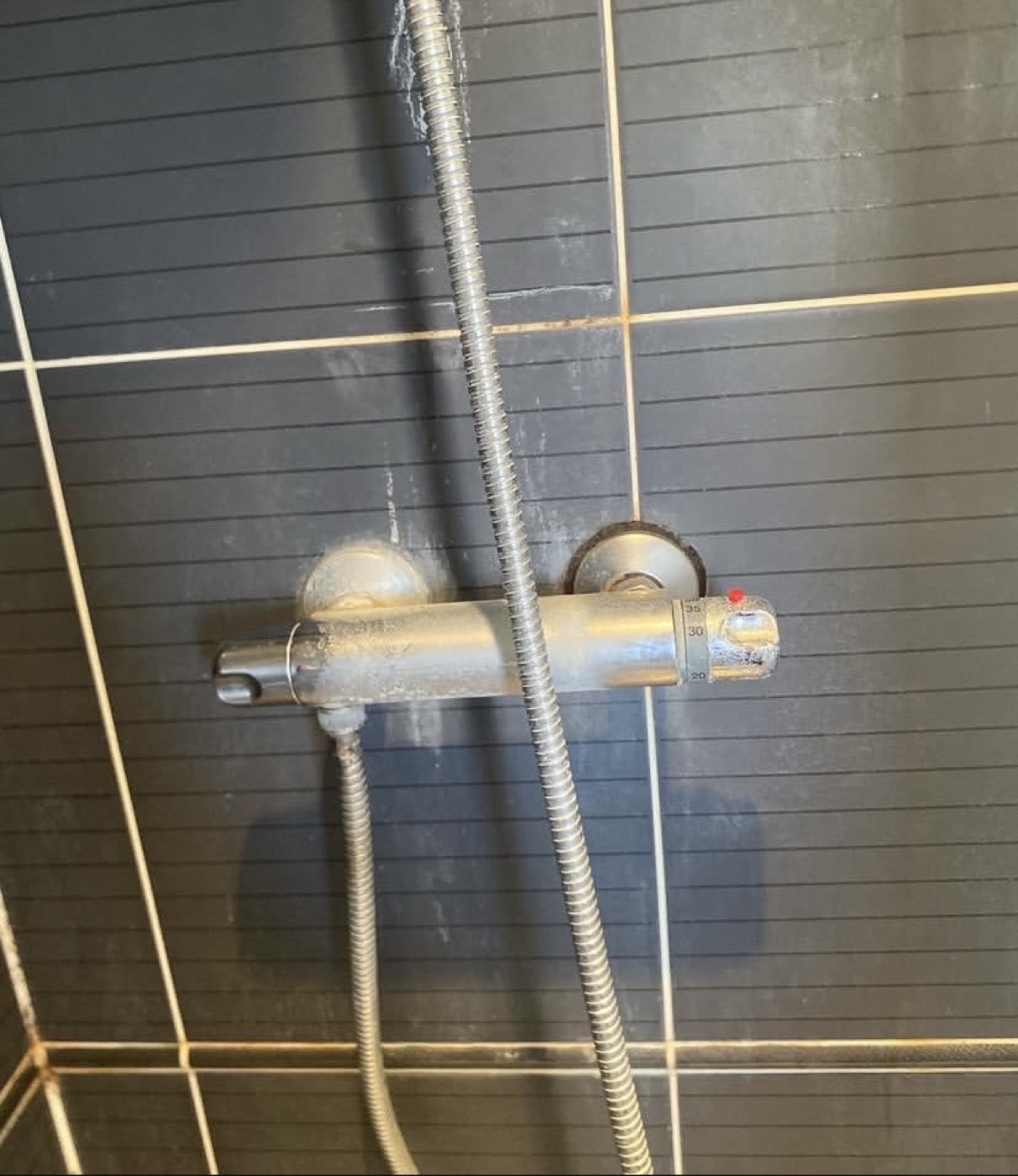 Before shower valve replacement with limescale around old shower mixer valve
